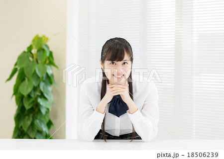 白いテーブルの前に座っている制服姿の女子高生 白いテーブルの前に座っている制服姿の女子高生 18506239