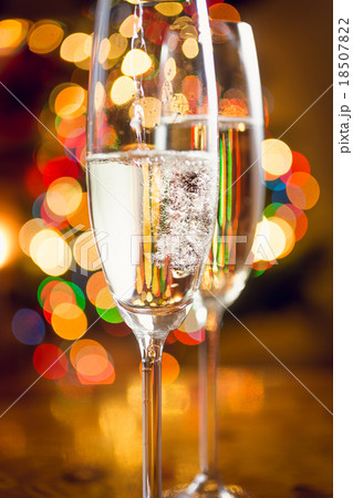 Macro of champagne poured in glass against lights Macro of champagne poured in glass against lights 18507822