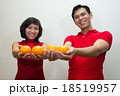 Young couple offering oranges as gold during CNY  18519957