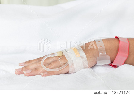 Hand of female patient with IV drip needle piercing in hospital Hand of female patient with IV drip needle piercing in hospital 18521120