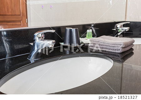 Washbasin with faucet and liquid soap bottle, towel at home 18521327