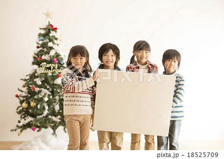 メッセージボードを持つ子供達とクリスマスツリー 18525709