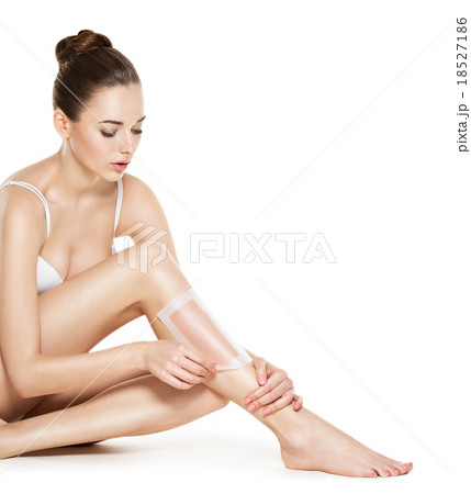 beautiful young woman depilating legs by waxing 18527186