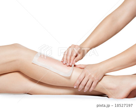woman depilating legs by waxing 18527197