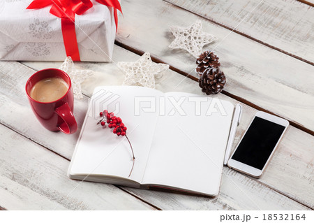 The open notebook on the wooden table with a phone 18532164