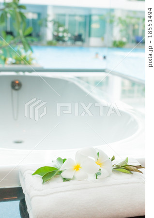 White bathtub with a pool view outside White bathtub with a pool view outside 18551494