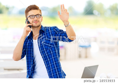 Pleasant guy holding mobile phone  18553933
