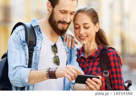 Pleasant couple holding mobile phone Pleasant couple holding mobile phone 18554360