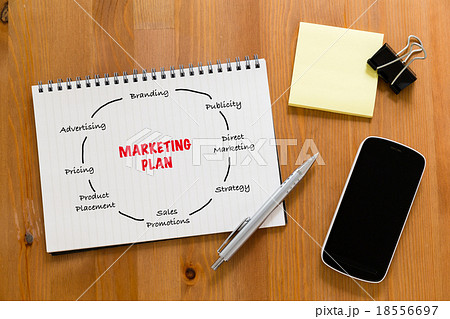 Working desk with mobile phone and handbook showing marketing pl Working desk with mobile phone and handbook showing marketing pl 18556697
