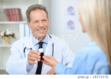 Smiling cardiologist talking to the patient Smiling cardiologist talking to the patient 18573570