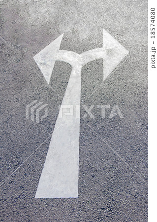 A two way arrow symbol on a black asphalt road A two way arrow symbol on a black asphalt road 18574080