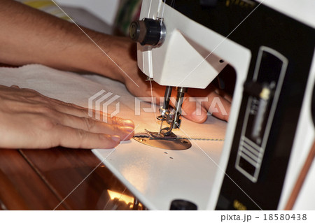 young man using a sewing machine young man using a sewing machine 18580438