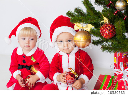 Two children under christmas pine Two children under christmas pine 18580583