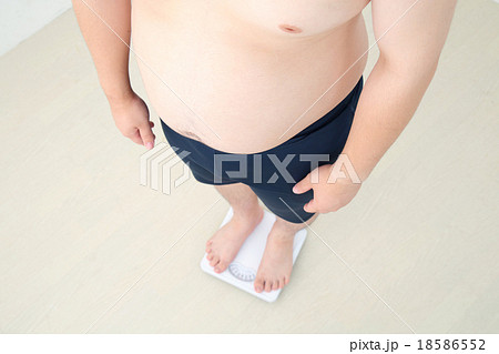 体重計に乗る男性 18586552