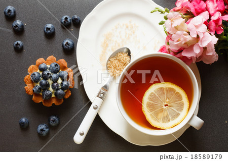 cup of tea with cake and flowers 18589179