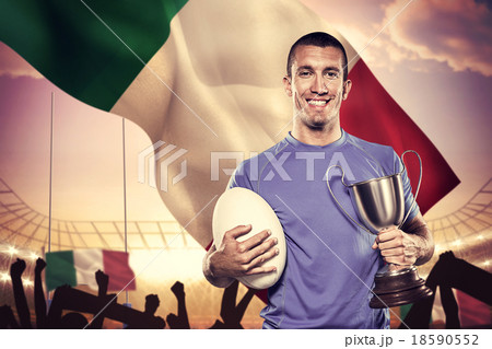Composite image of portrait of smiling rugby player holding trop 18590552