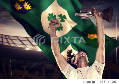 Composite image of happy rugby player holding trophy Composite image of happy rugby player holding trophy 18591106