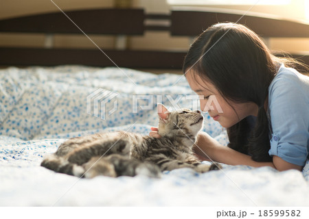 Beautiful asian girl kissing american shorthair cat 18599582