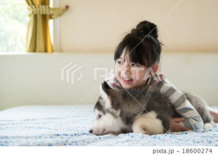 Little asian girl hugging a siberian husky puppy 18600274