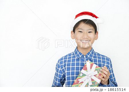 クリスマスプレゼントを持つ男の子 小学生 中学生 クリスマス プレゼント クリスマスイメージの写真素材