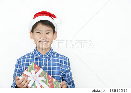 クリスマスプレゼントを持つ男の子 小学生 中学生 クリスマス プレゼント クリスマスイメージの写真素材