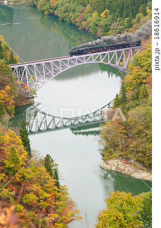 紅葉の只見川第一橋梁を渡るsl只見線紅葉号の写真素材