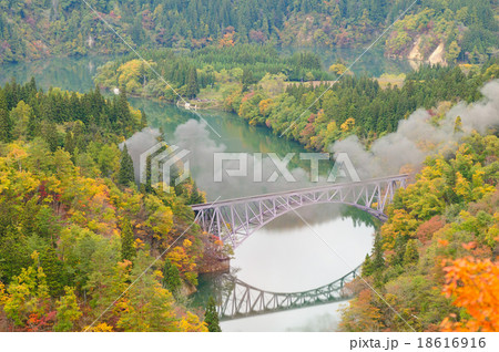 紅葉の只見川第一橋梁に残るsl只見線紅葉号の煙の写真素材