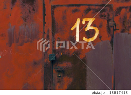 Number thirteen on red metal locked door. 18617418
