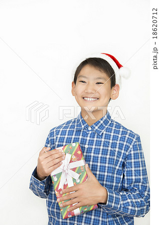 クリスマスプレゼントを持つ男の子 小学生 中学生 クリスマス プレゼント クリスマスイメージの写真素材