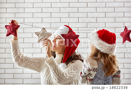 mother and daughter hang a garland mother and daughter hang a garland 18622336