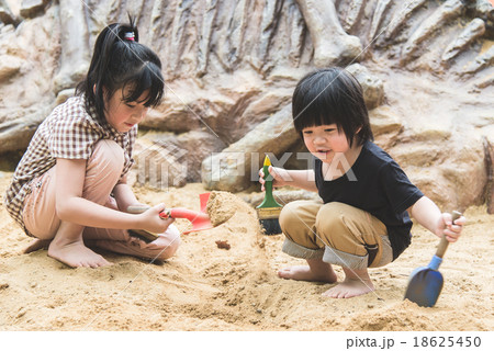 Little asian children has fun digging in the sand 18625450