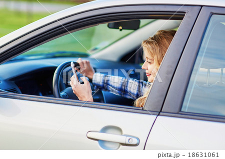 young woman driving a car and using phone young woman driving a car and using phone 18631061