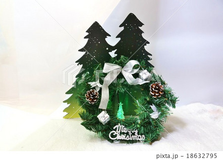 クリスマスイメージ・雪の森と緑のクリスマスリースの中に緑の光のツリー・横位置 クリスマスイメージ・雪の森と緑のクリスマスリースの中に緑の光のツリー・横位置 18632795