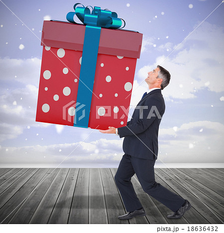 Composite image of stylish man with giant gift Composite image of stylish man with giant gift 18636432