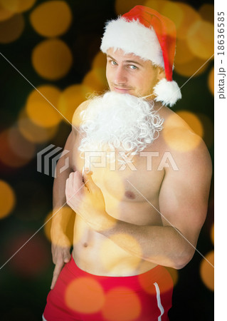 Composite image of smiling muscular man posing in sexy santa out Composite image of smiling muscular man posing in sexy santa out 18636585