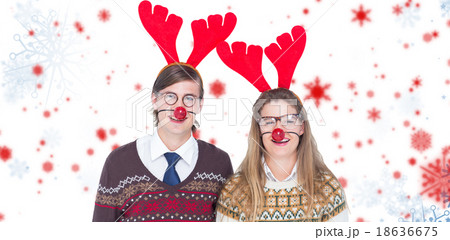 Composite image of portrait of smiling man and woman wearing red reindeer horn 18636675