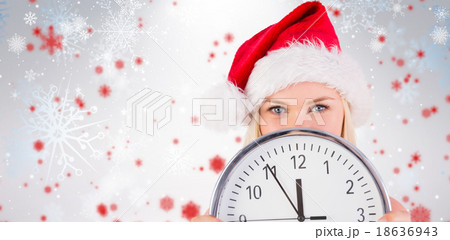 Composite image of festive blonde holding a clock Composite image of festive blonde holding a clock 18636943