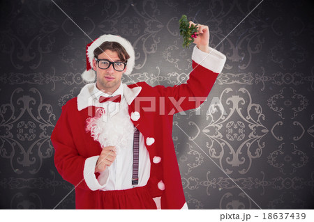Composite image of geeky hipster in santa costume holding mistle 18637439