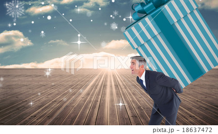 Composite image of stylish man with giant gift 18637472