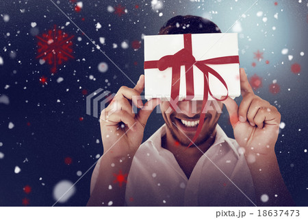 Composite image of man holding gift 18637473