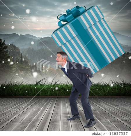 Composite image of stylish man with giant gift Composite image of stylish man with giant gift 18637537