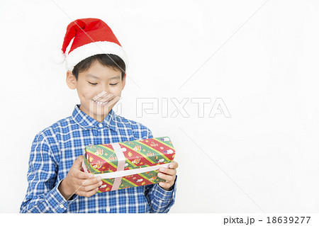 クリスマスプレゼントを持つ男の子 小学生 中学生 クリスマス プレゼント クリスマスイメージの写真素材