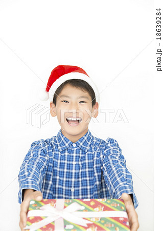 クリスマスプレゼントを持つ男の子 小学生 中学生 クリスマス プレゼント クリスマスイメージの写真素材