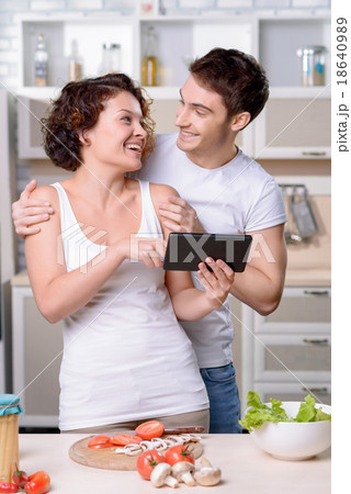 Content loving couple having fun in the kitchen Content loving couple having fun in the kitchen 18640989