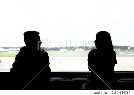 横並びで会話する男女の後ろ姿の写真素材