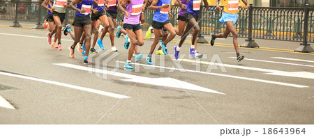 marathon runners running on city road 18643964