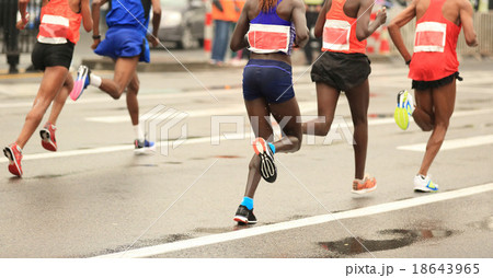 marathon runners running on city road 18643965