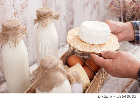 Skillful senior farmer with fresh dairy products Skillful senior farmer with fresh dairy products 18648683