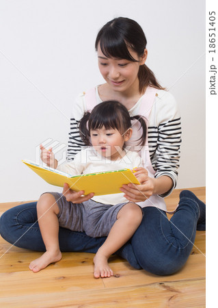 絵本を読み聞かせる保育士の写真素材