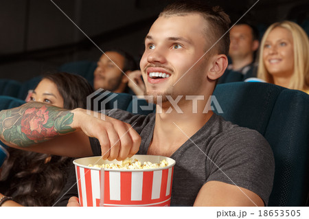Young man laughing during a comedy film Young man laughing during a comedy film 18653505